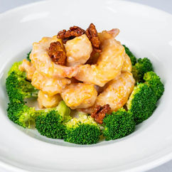 Delicious shrimp dish with broccoli and garnish in a white bowl.