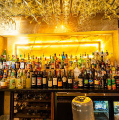 Bar filled with liquor bottles and glasses hanging above the counter.